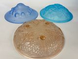 trois moules à gâteau en plastique posés sur une surface blanche