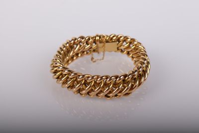un bracelet en or avec un motif tressé sur un fond blanc