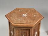 a small wooden table with a carved design on it