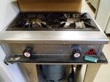 a gas stove that is in a kitchen with two burners
