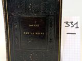 un vieux livre posé sur une table à côté d'une feuille de papier