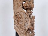 une photo d'une sculpture en bois posée sur un socle, sur une surface blanche