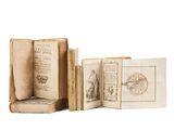 three old books are sitting on top of each other on a white surface