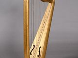 a golden harp sitting on a stand on a gray surface