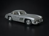 a silver toy car that is sitting on a black surface