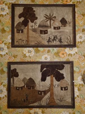 three framed pictures of houses and trees on a wall in a room