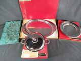 a red box with a black lid and a silver pan in it