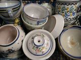 un panier rempli de différentes sortes de poteries posé sur la table