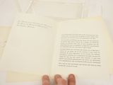 a person holding a book open on top of a table