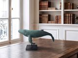 a statue of a dolphin sitting on a desk in a room