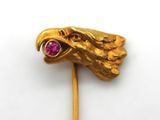 an image of a gold stick with a red stone in the shape of a head