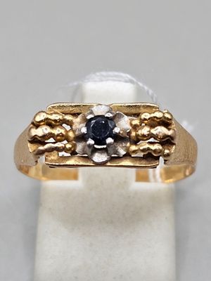 gros plan d'une bague en or avec un diamant noir
