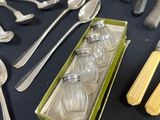 a lot of silverware on a table with spoons and forks