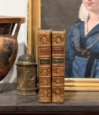 un tableau représentant une femme en robe bleue, à côté de livres et d'un vase
