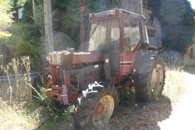 un tracteur rouge garé dans l'herbe