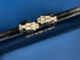 a close up of a black and gold pen with a snake on it