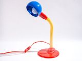 une lampe rouge et bleue posée sur une table