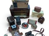 de nombreux appareils photo anciens et d'autres objets posés sur une surface blanche