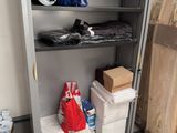 une armoire métallique sur laquelle sont posés de nombreux objets, dans une pièce