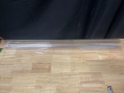un morceau de plastique transparent posé sur une table en bois