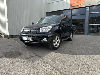 la photo d'une voiture noire garée devant un bâtiment