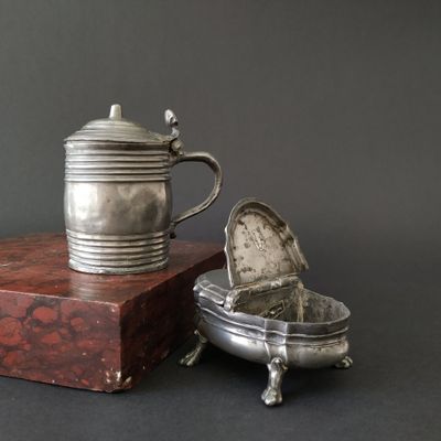 a silver teapot sitting on top of a wooden box