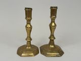 pair of antique brass candlesticks on a white background