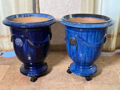 deux vases bleus posés l'un à côté de l'autre sur le sol