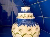 un vase bleu et blanc posé sur un plan de travail carrelé de bleu