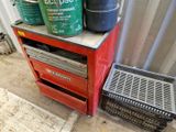 une armoire rouge sur laquelle sont posés deux seaux, à côté d'une poubelle