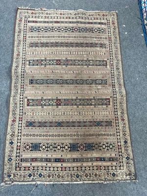 un tapis posé à même le sol, avec une chaise bleue en arrière-plan