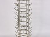 a tall metal wine rack with many bottles in it