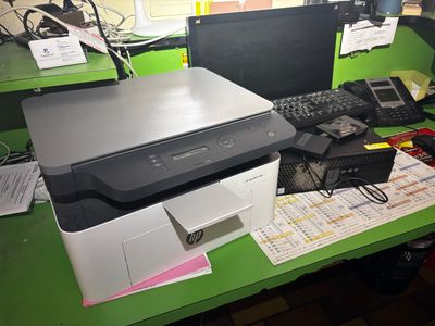 une imprimante posée sur un bureau à côté d'un ordinateur