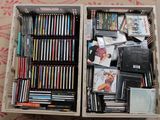une boîte remplie de DVD et de CD posée par terre
