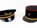 pair of black and gold military hats on a white background