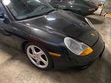 a black sports car parked in a garage with other cars in the background