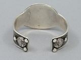 a close up of a silver ring with two skulls on it