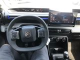 someone is sitting in the driver ' s seat of a car with their feet on the steering wheel