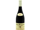 a bottle of red wine sitting on top of a white table