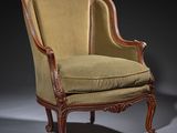 an antique chair with a green upholstered seat and a wooden frame