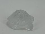 a glass turtle that is sitting on a table
