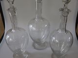 trois carafes en verre posées sur une table blanche