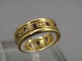 Gros plan sur une bague en or ornée de pierres rouges