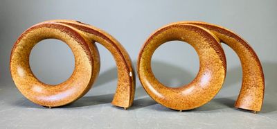 deux sculptures en bois représentant un motif en spirale sur une surface grise