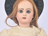 a doll that is wearing a black hat and dress