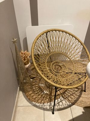 une chaise en osier dans un coin de la salle de bains