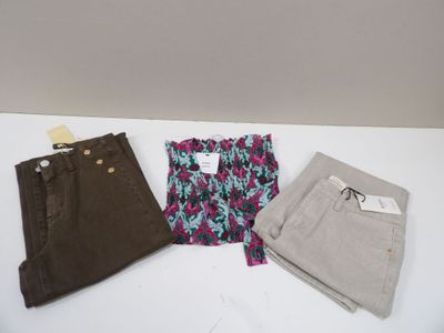 trois paires de pantalons pour femmes posées sur une table blanche