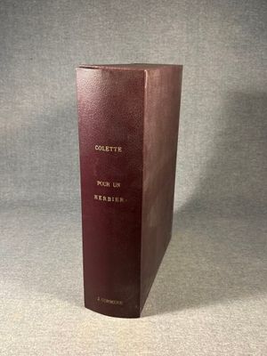 a brown book sitting on top of a table next to a gray wall