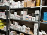 boxes are stacked on shelves in a warehouse with a man in the background