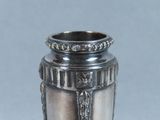 a silver vase that is sitting on a table
